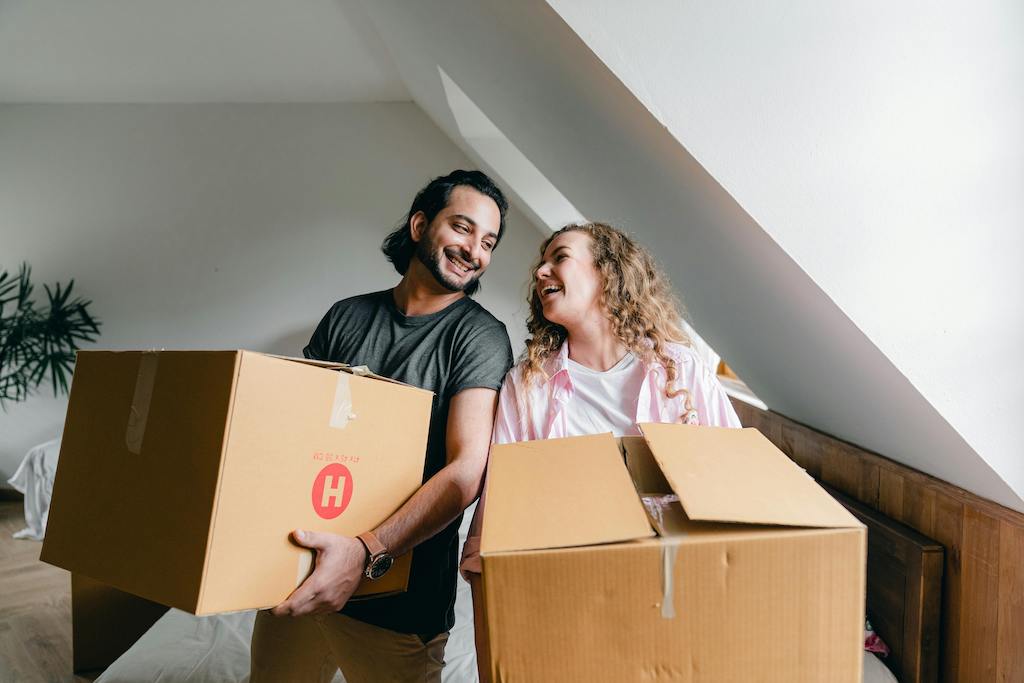 Husband and wife moving boxes together, assisted by a trusted removals company in Hampshire